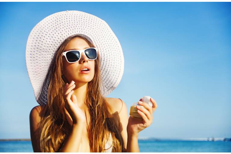 Женщина наносит крем с SPF
