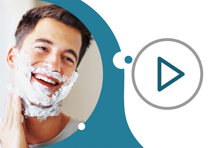 улыбающийся темноволосый мужчина покрывает лицо пеной для бритья