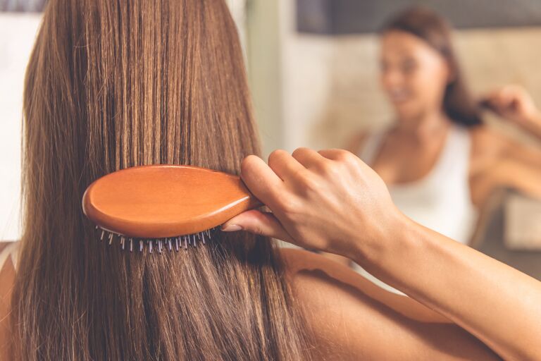 Девушка показывает как выпрямить волосы без утюжка с помощью щетки