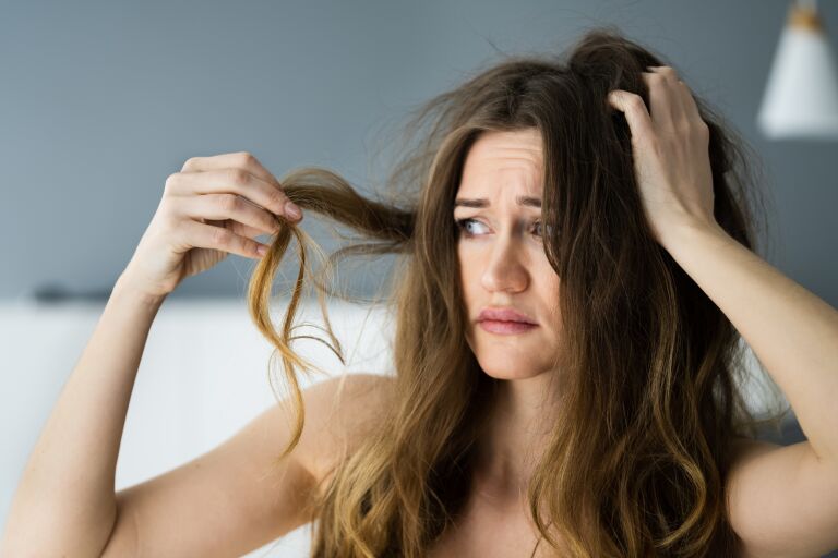 Расстроенная девушка из-за выпадения волос после родов