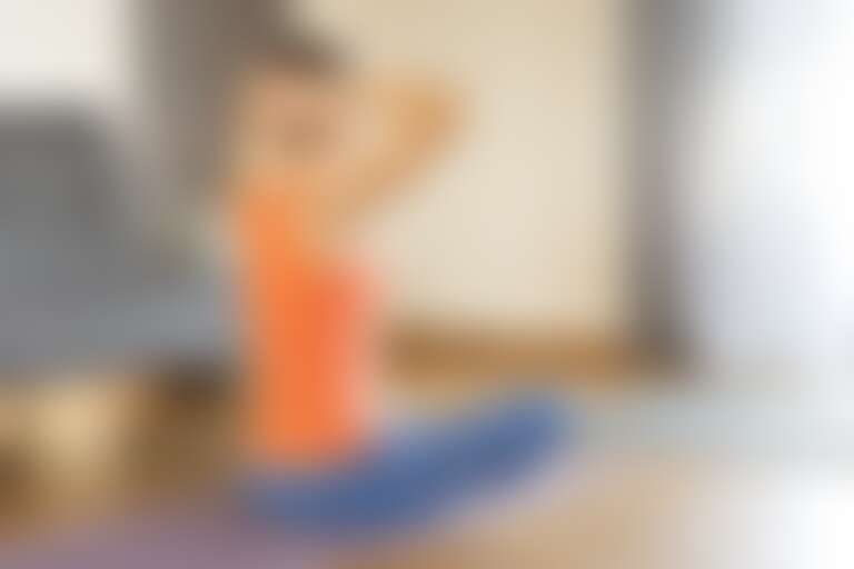 Young woman making exercise for her back at the kitchen home