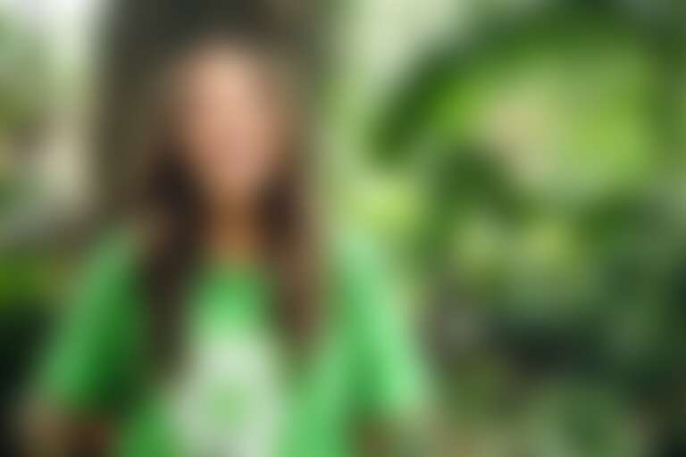 девушка в зеленой футболке с символом переработки пластика для этичной косметики